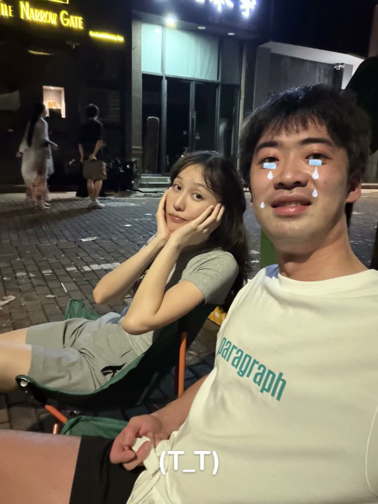 A couple at night, one of them with the (T_T) Crying filter